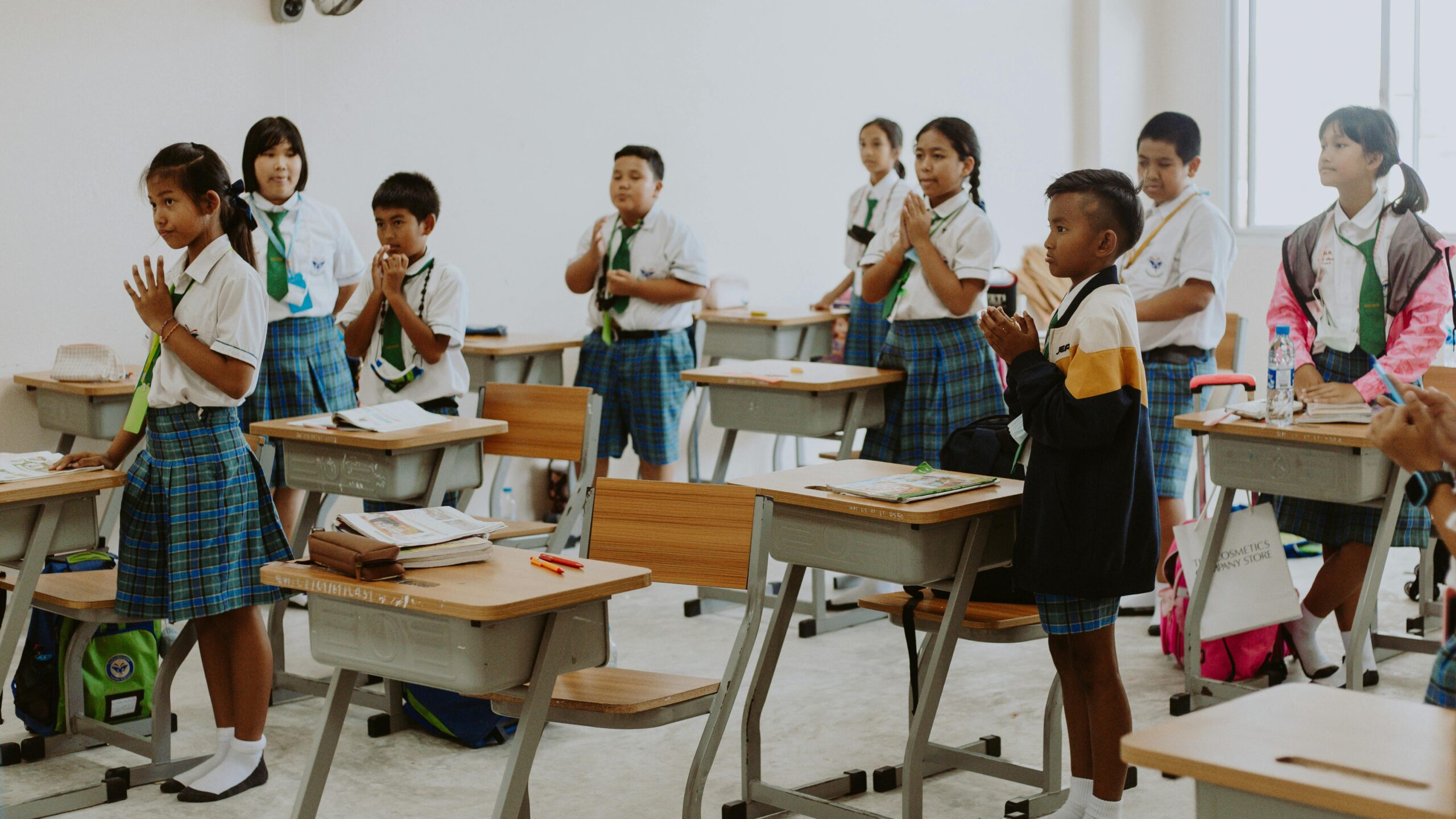 Group of students wearing uniforms in a classroom, engaged in an activity.